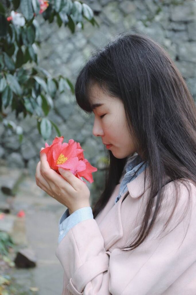women smelling flower for senior picture in the spring