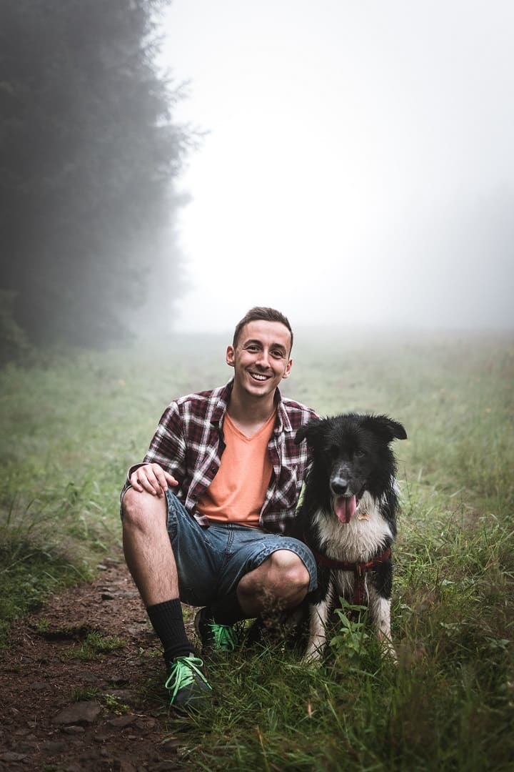 Misty senior photo of a young man and his dog